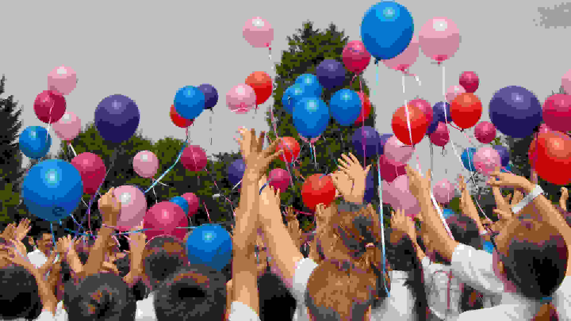 School children flying balloons