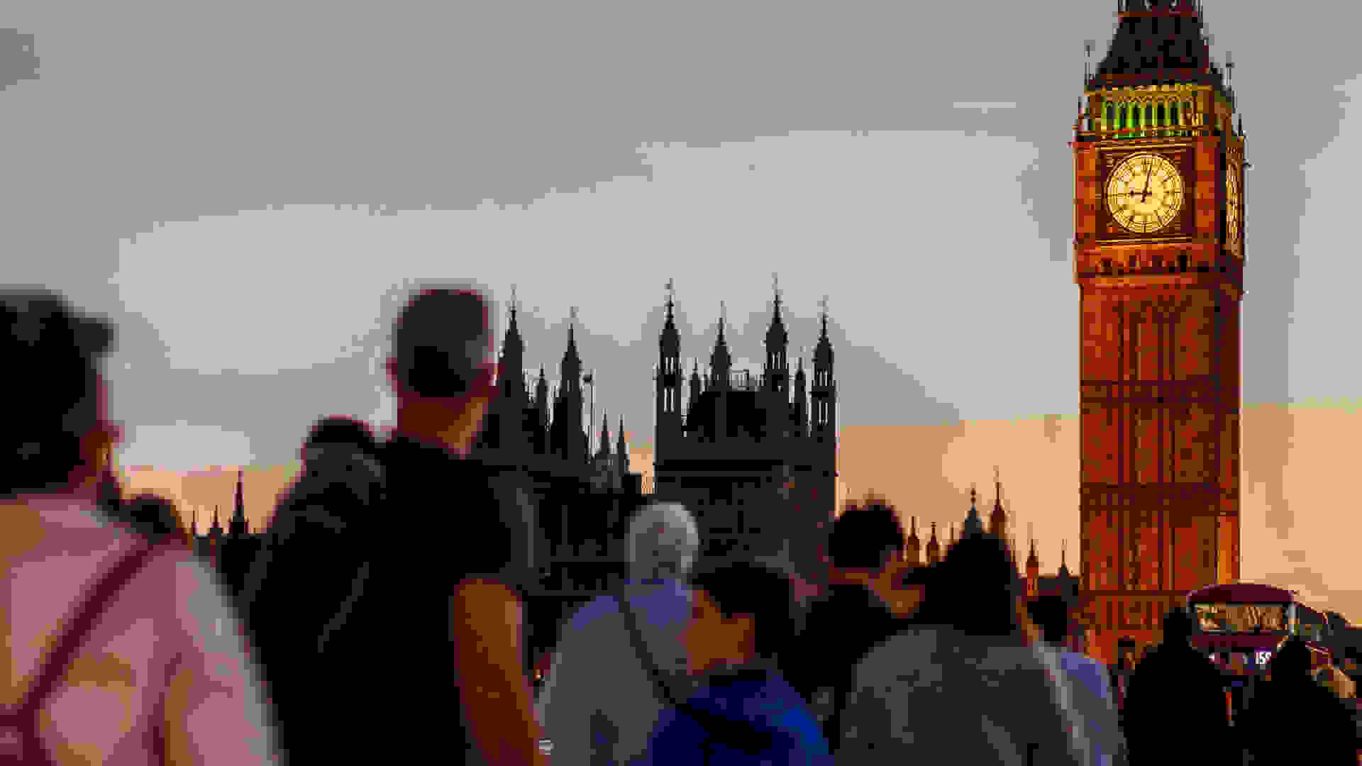 People walking over Westminster Bridge towards the UK Houses of Parliament