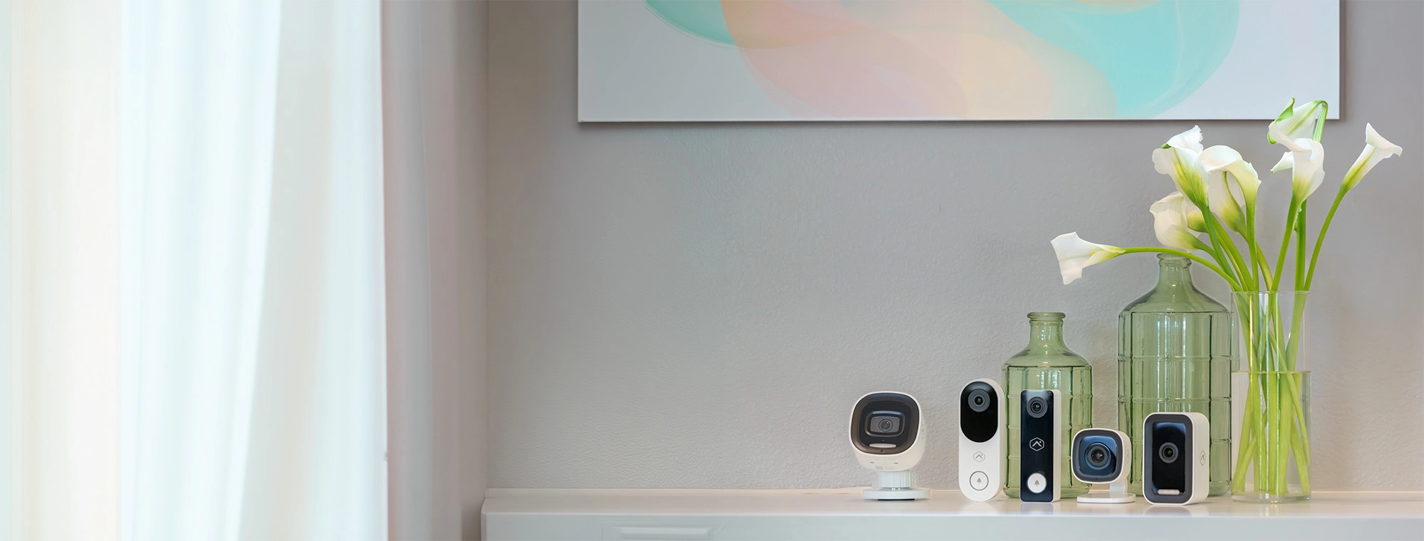 Brinks Home security system equipment, including video doorbell, outdoor/indoor camera, arranged neatly on a tabletop alongside home decor.