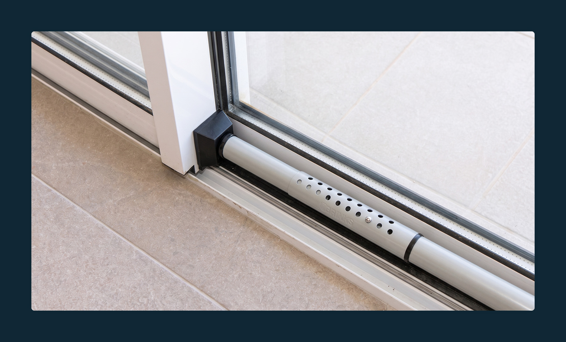 A metal rod positioned to stop a sliding glass door from opening.