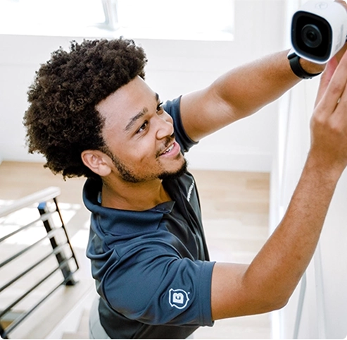 Technician installing indoor camera as part of Brinks Home security systems