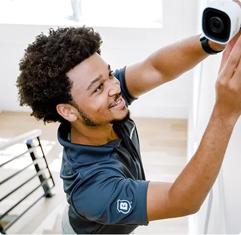 Technician installing indoor camera as part of Brinks Home security systems