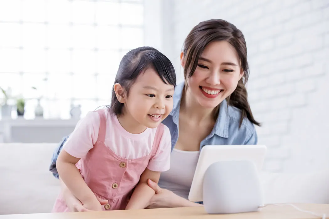 Mother and daughter interacting with a smart device