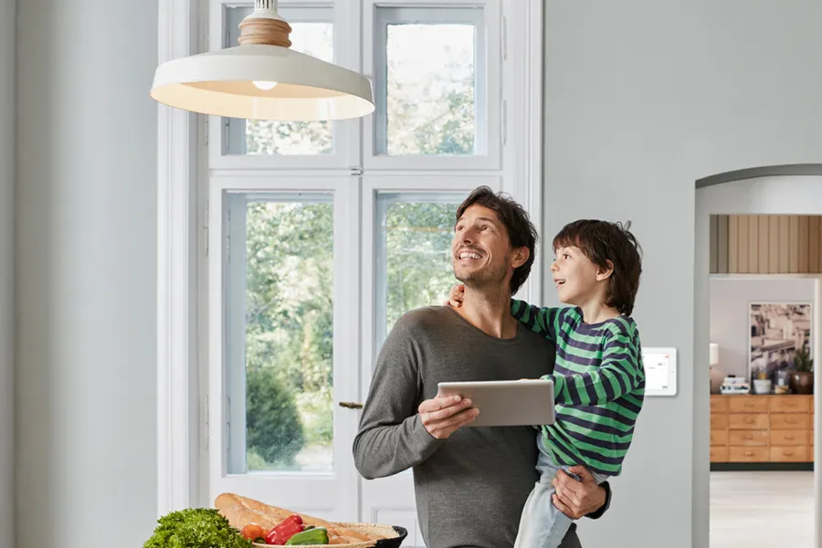 Father and son looking at a smart lamp