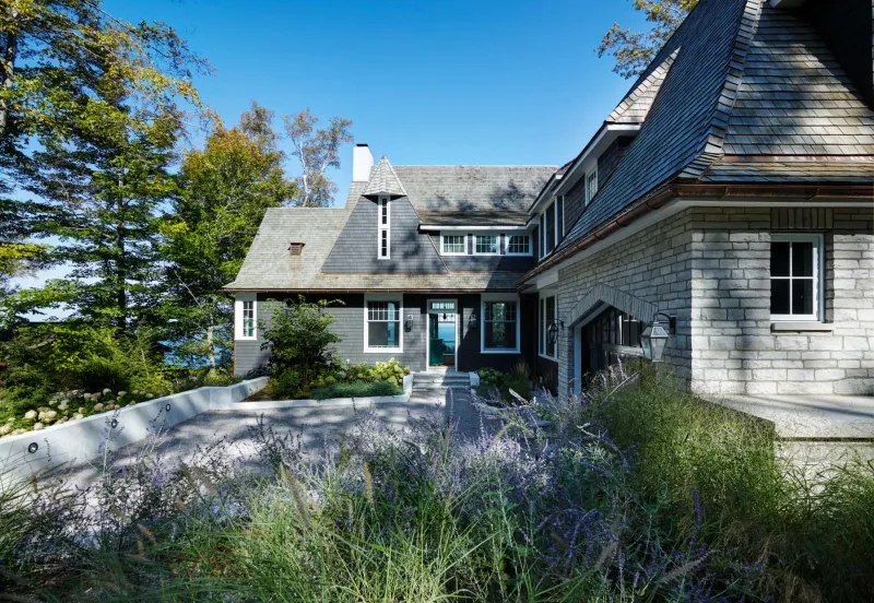A vacation retreat on Lake Michigan with storybook details such as shingled siding, a gabled roofline and a Western red cedar shake roof. 