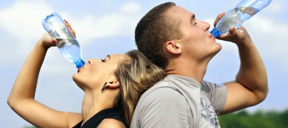 Man en vrouw drinken water uit flesje