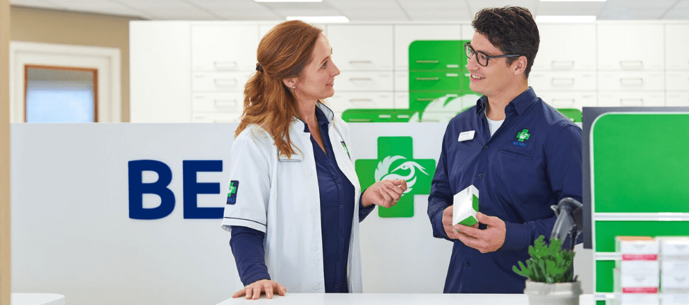 Apotheker en apothekersassistent in gesprek over een medicijn.