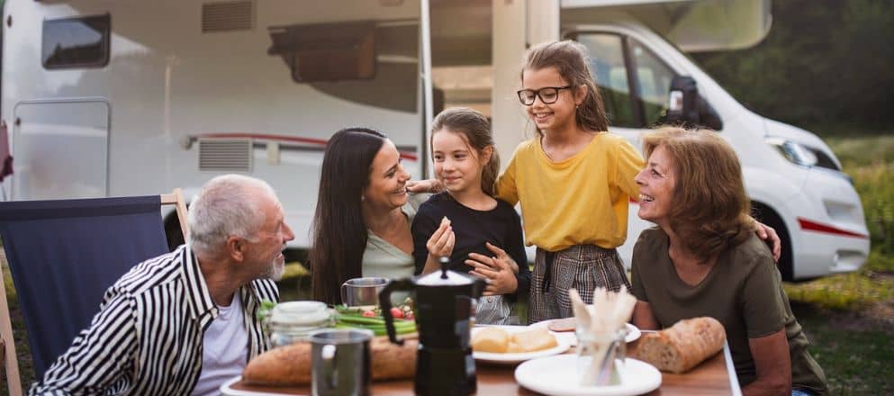 Familie aan tafel voor de camper
