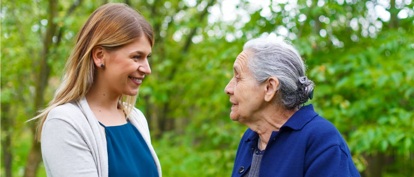 Oudere dame in gesprek met kleindochter in het park