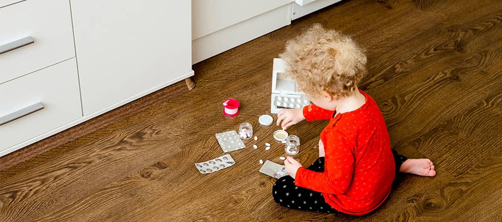 Kindje speelt met medicijnen op de vloer