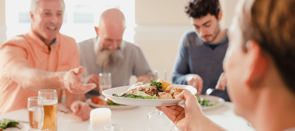 man geeft een bord door aan tafel