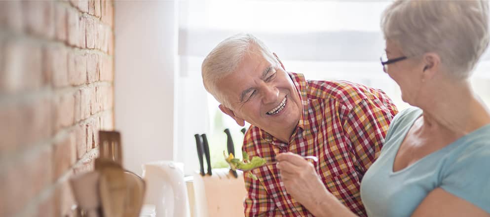 Ouder stel is lachend aan het koken