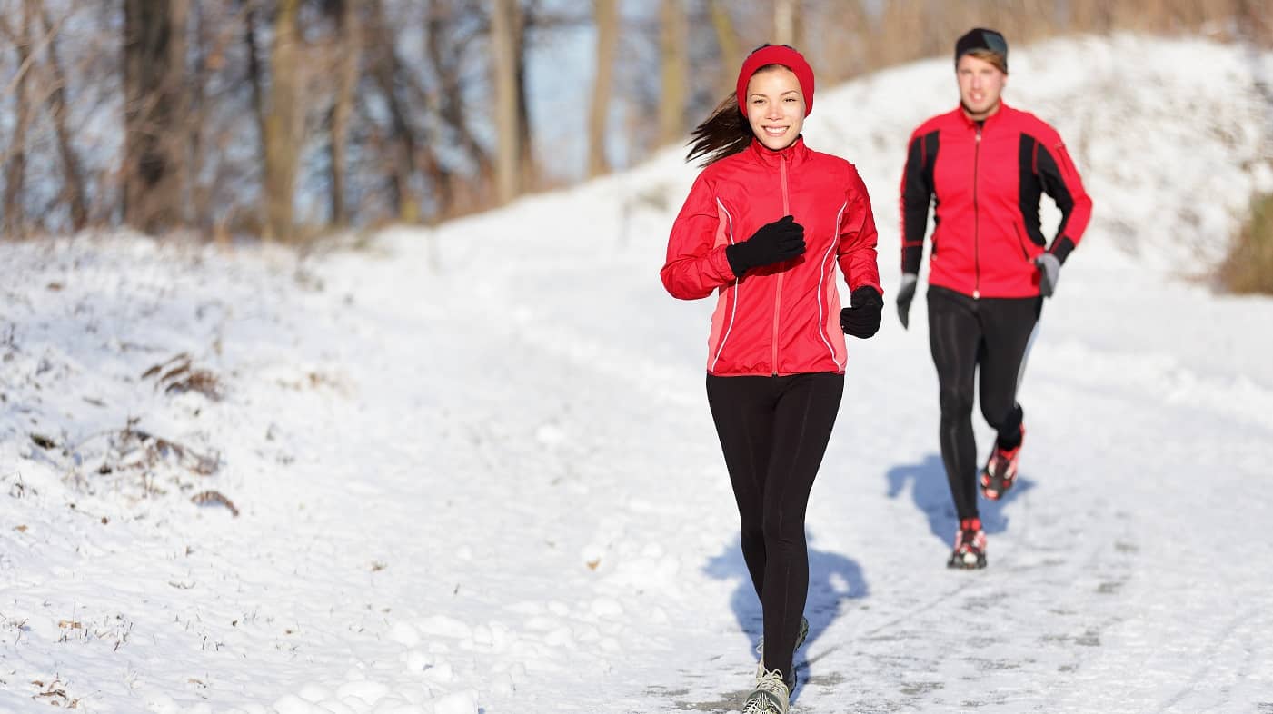 Man en vrouw lopen hard in de sneeuw