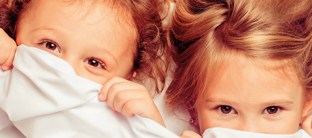 twee zusjes liggen in bed