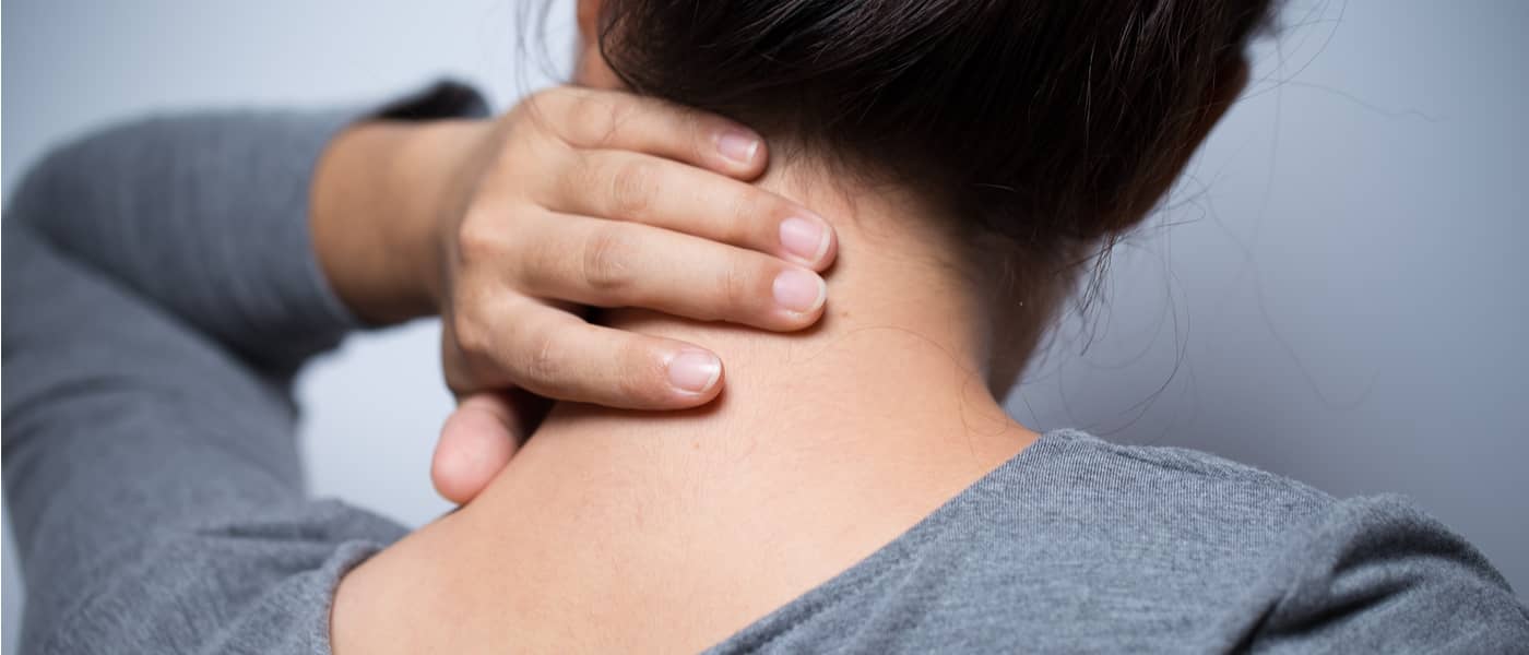Een vrouw met gewrichtspijn grijpt naar haar nek