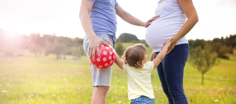 Familie buiten met zwangere mama