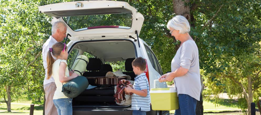 Familie pakt auto in voor een kampeervakantie.