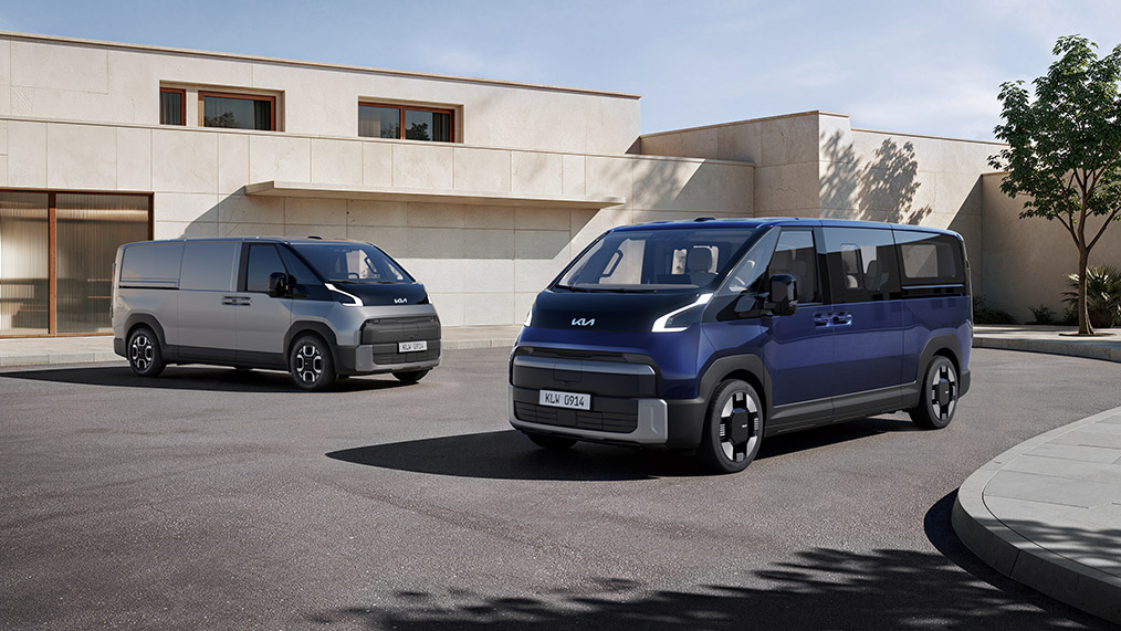 Kia PV7 Passenger in Dunkelblau und PV7 Cargo in Grau in einer modernen urbanen Umgebung vor heller, minimalistischer Architektur. Beide Fahrzeuge sind in einer Dreiviertelansicht von vorn dargestellt.