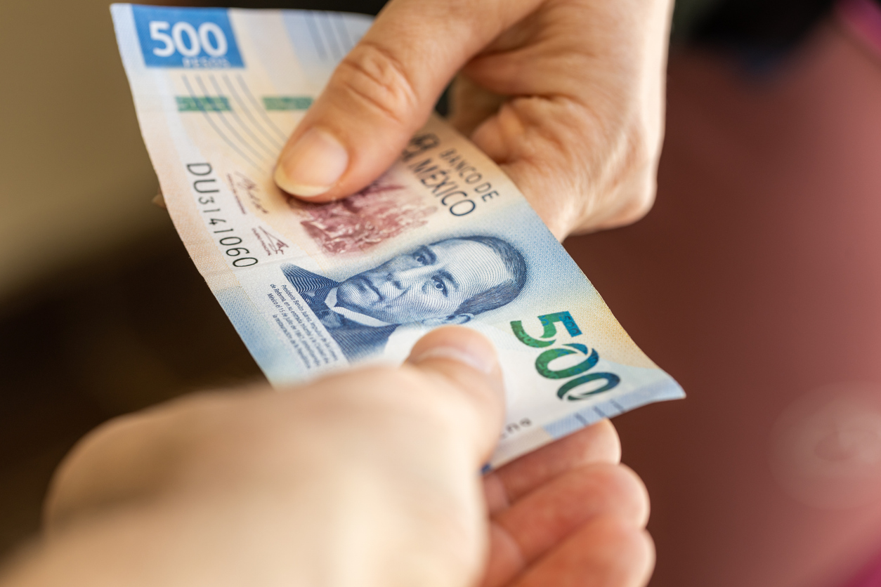 Persona pagando a gestor por sus servicios para la gestoría vehicular