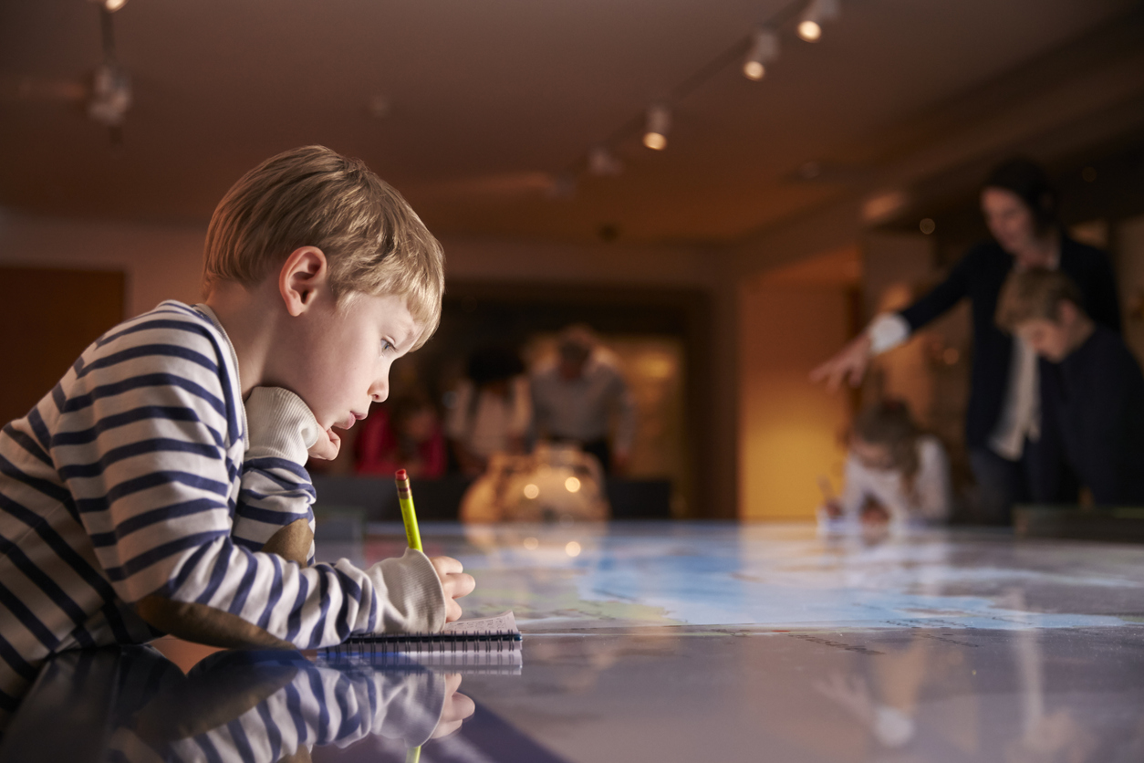 Niño en museo tomando apuntes