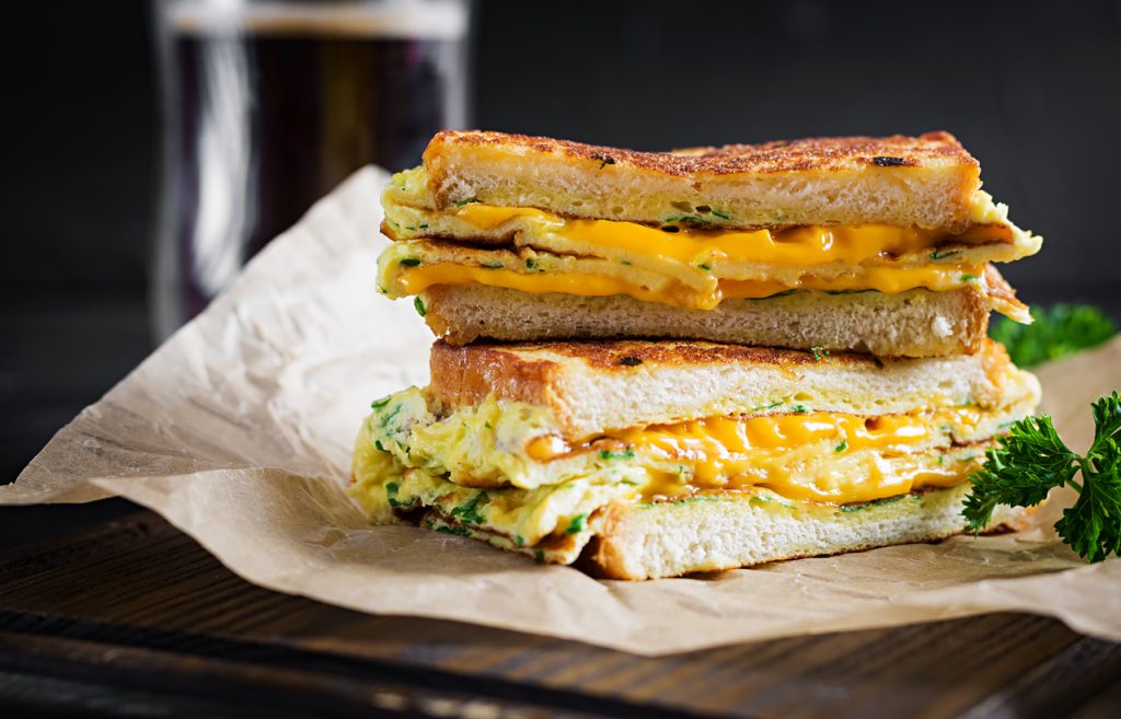 Sándwich tostado con queso amarillo y huevos revueltos