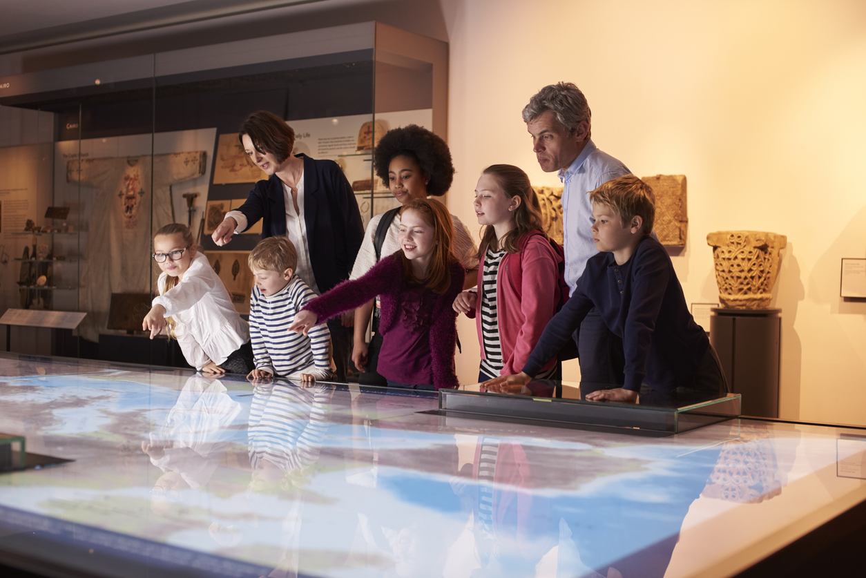 Niños interactuando con mapa digital en museo interactivo