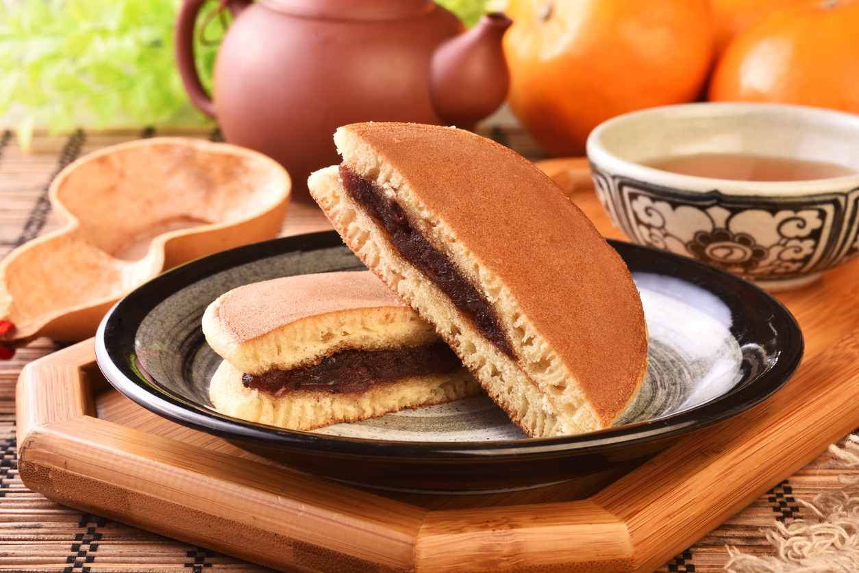 El dorayaki es un postre japonés clásico que consiste en dos bizcochos esponjosos rellenos de anko, una pasta dulce de frijoles rojos, ofreciendo un equilibrio perfecto entre dulzura y textura.