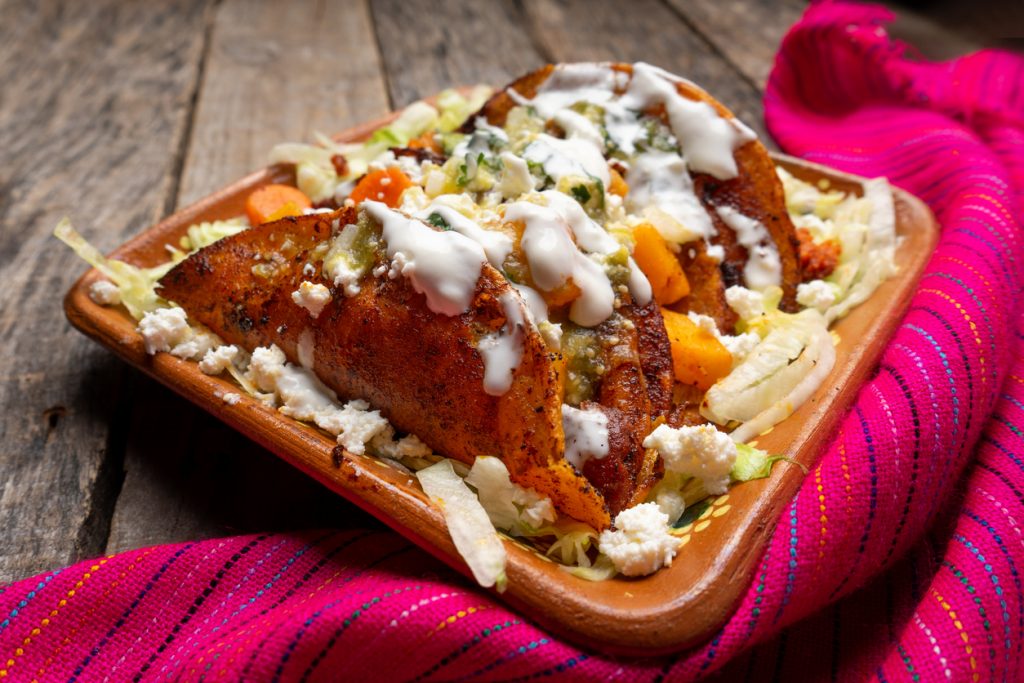 Exquisitas enchiladas potosinas rojas con queso.