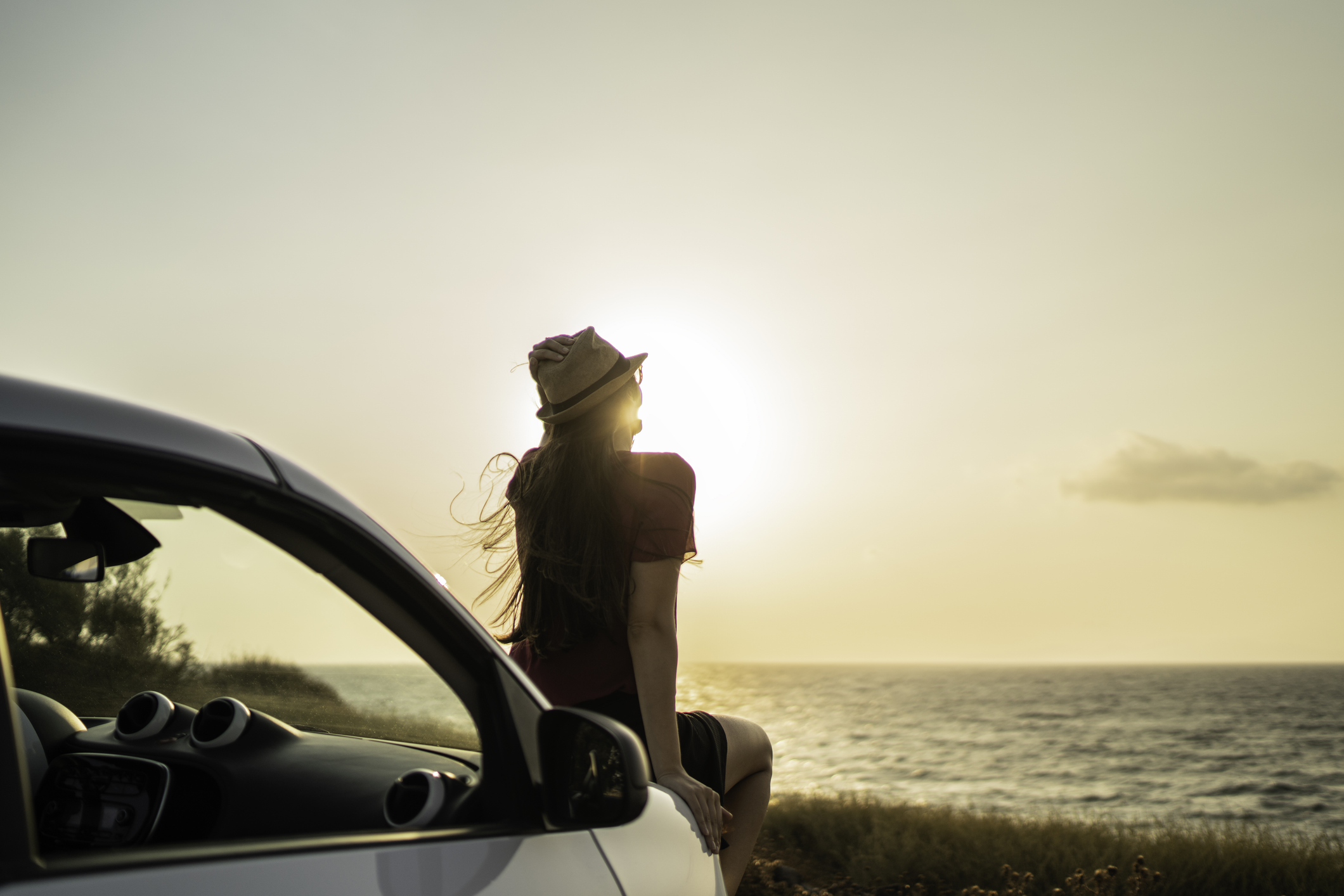 Mujer mirando el atardecer en carretera