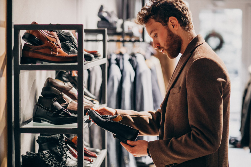 young-handsome-man-choosing-shoes-shop