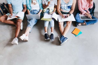 overhead-portrait-young-people-with-laptops-smartphones-sitting-together-floor-students-writing-lectures-holding-textbooks-t (4)