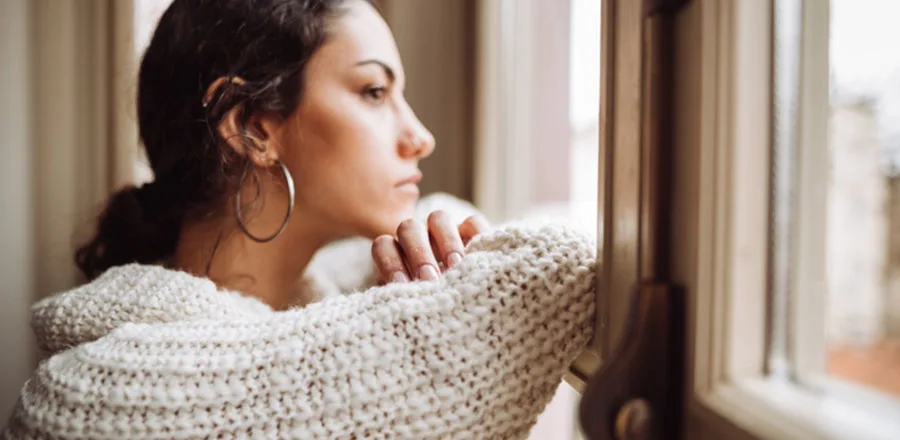 Triste jeune femme regardant par la fenêtre