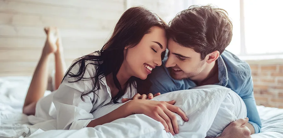 Happy couple in love lying on bed