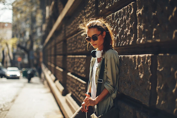 Teenage girl leaning against a wall