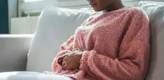 Woman with stomach pain is holding her aching belly