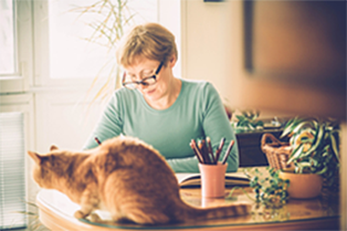 A woman sitting at a desk with a cat