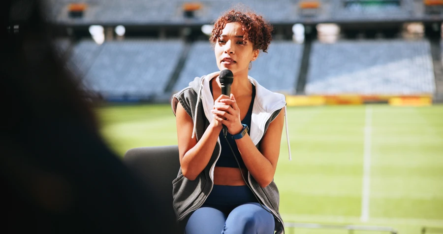 Person speaking into microphone at outdoor stadium