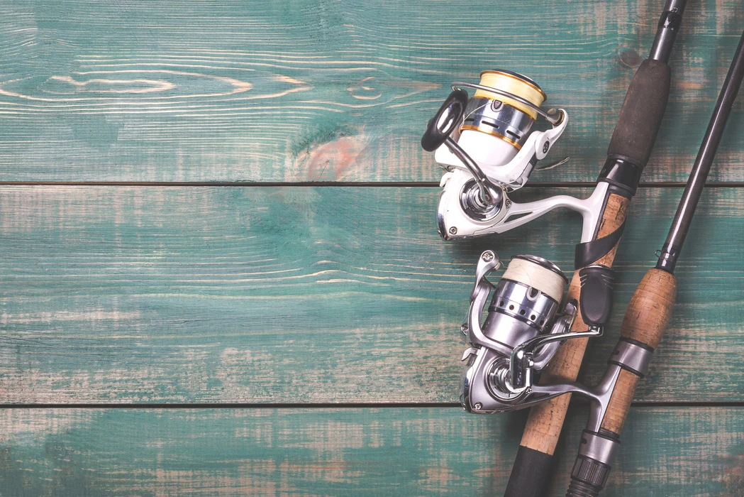 Two fishing poles on a wooden table