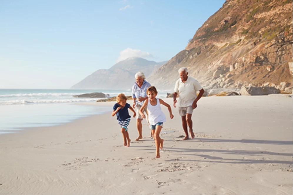 Grandparents and Grandchildren running on a beach