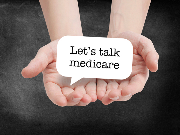 Childs hands holding a small medicare sign