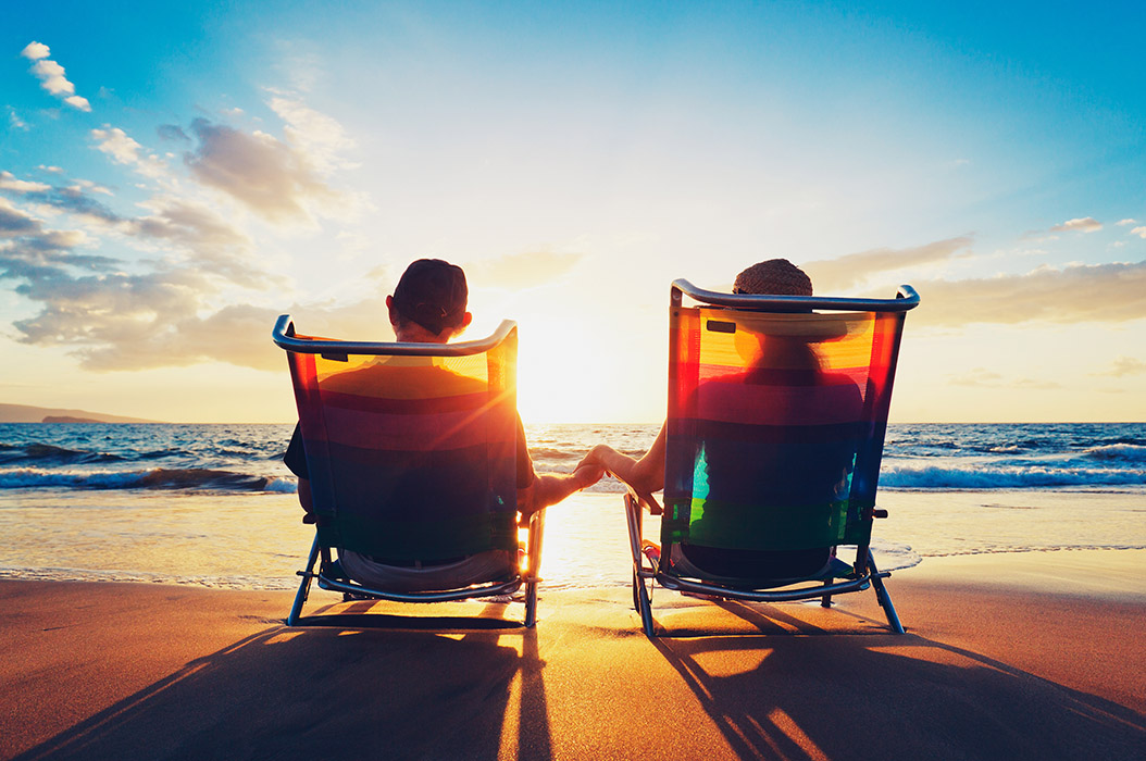 Two people sitting on chairs on a beach