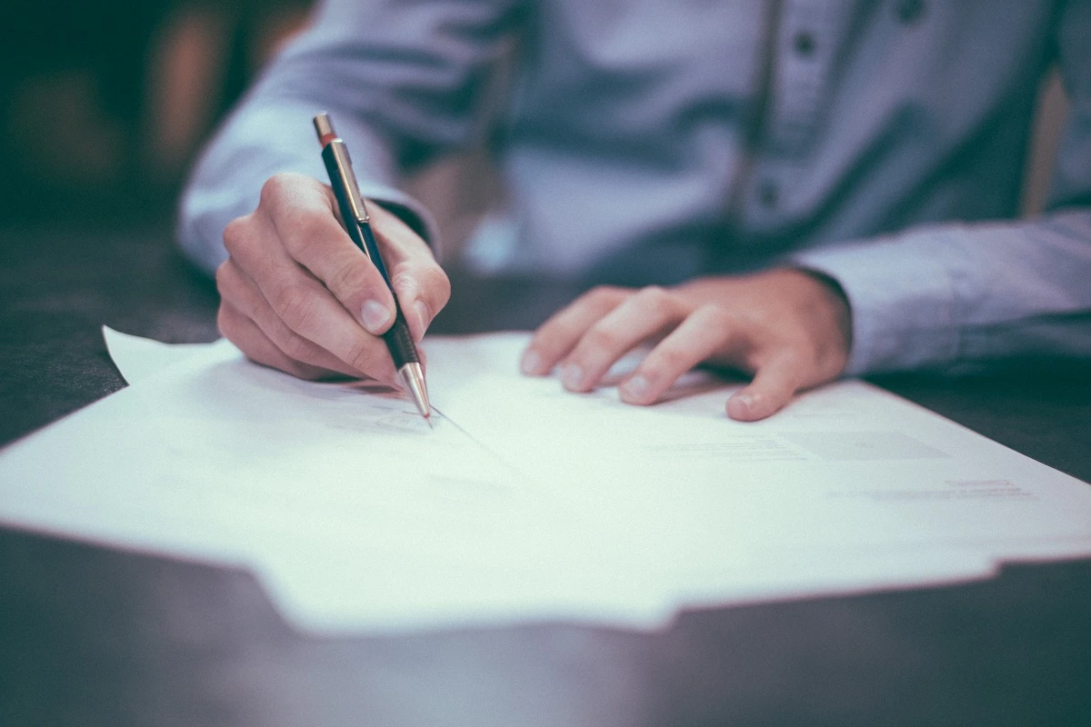 man with a pen signing a contract