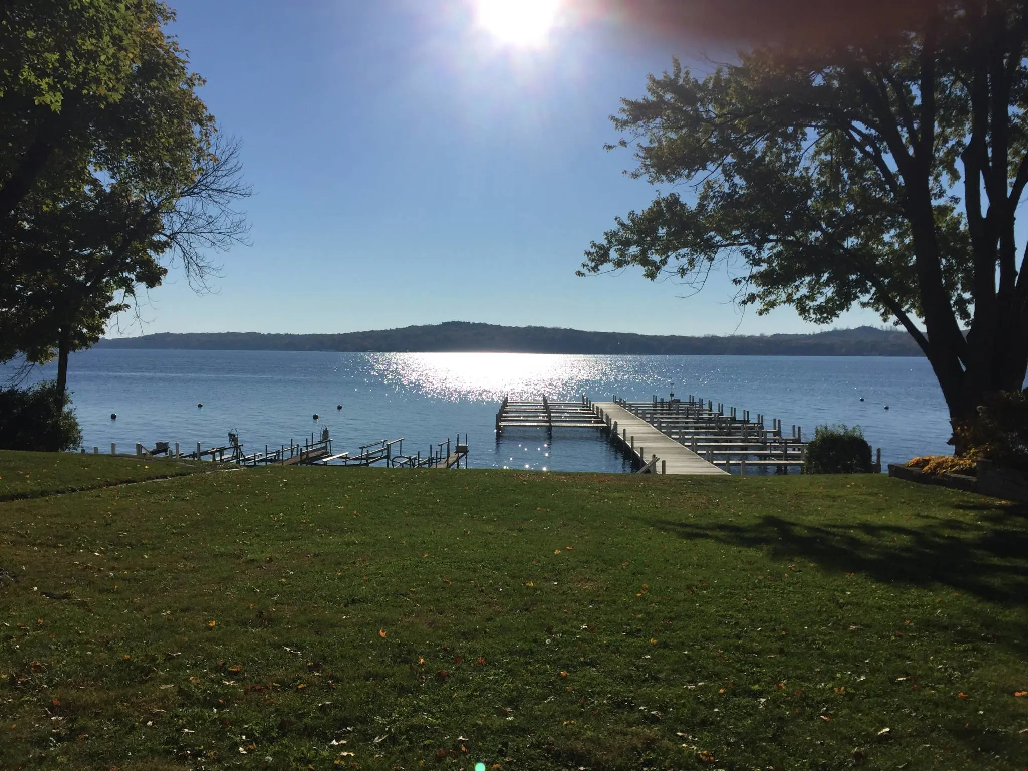 A view over a large lake from a grassy backyard