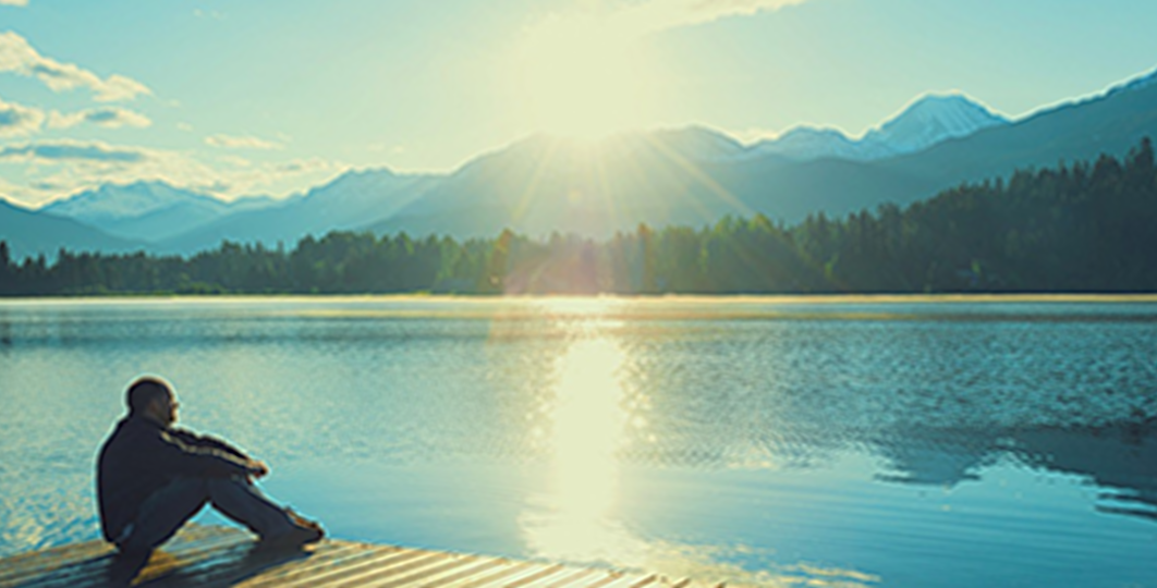 man reflecting along the water