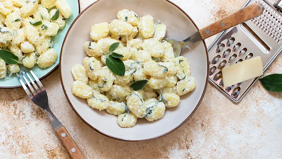 Creamy gnocchi topped with fresh sage and cheese