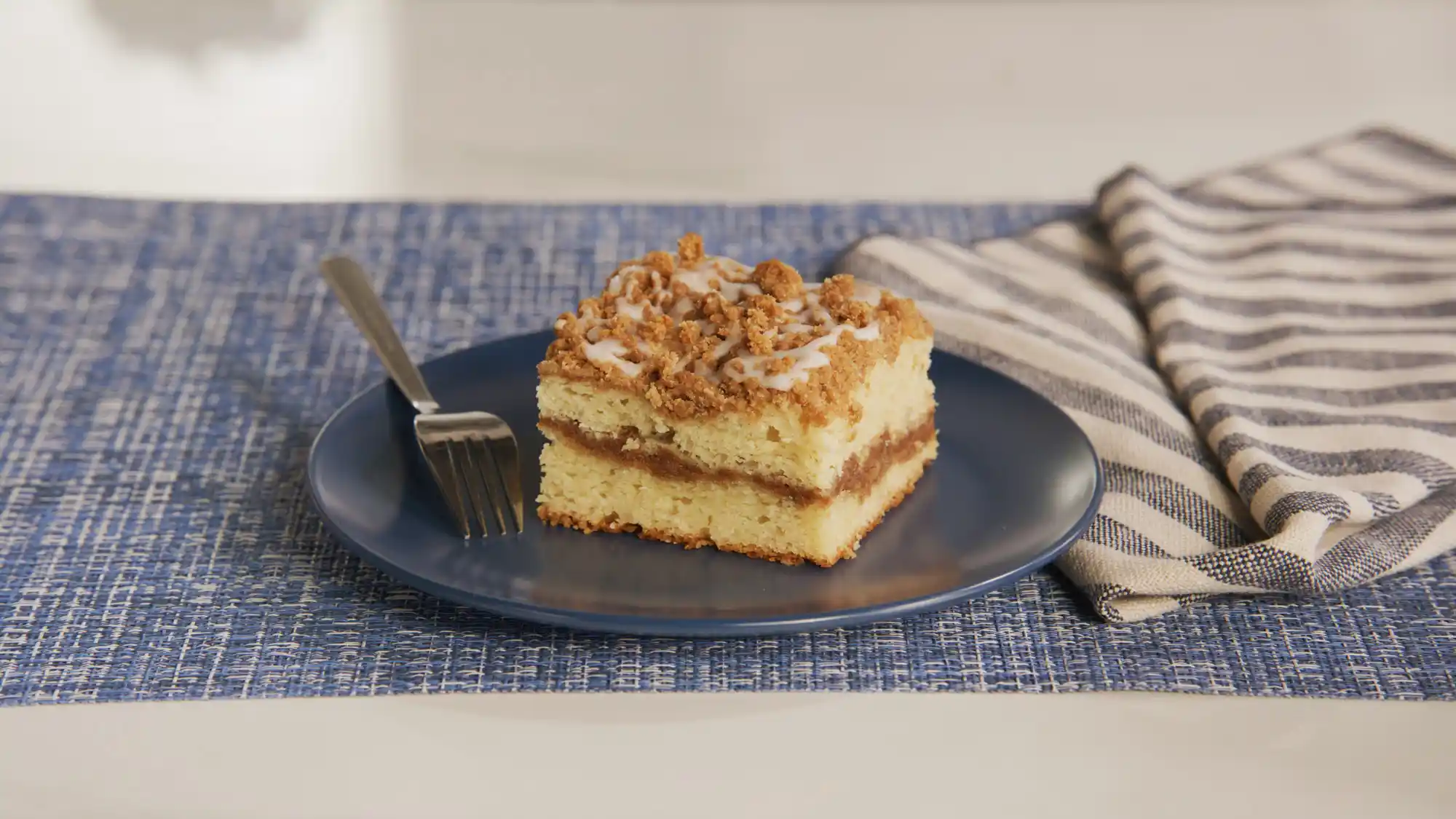 Delicious coffee cake with a golden crumb and a crumbly streusel topping, served on a wooden cutting board with a slice cut out, ideal for breakfast or brunch.