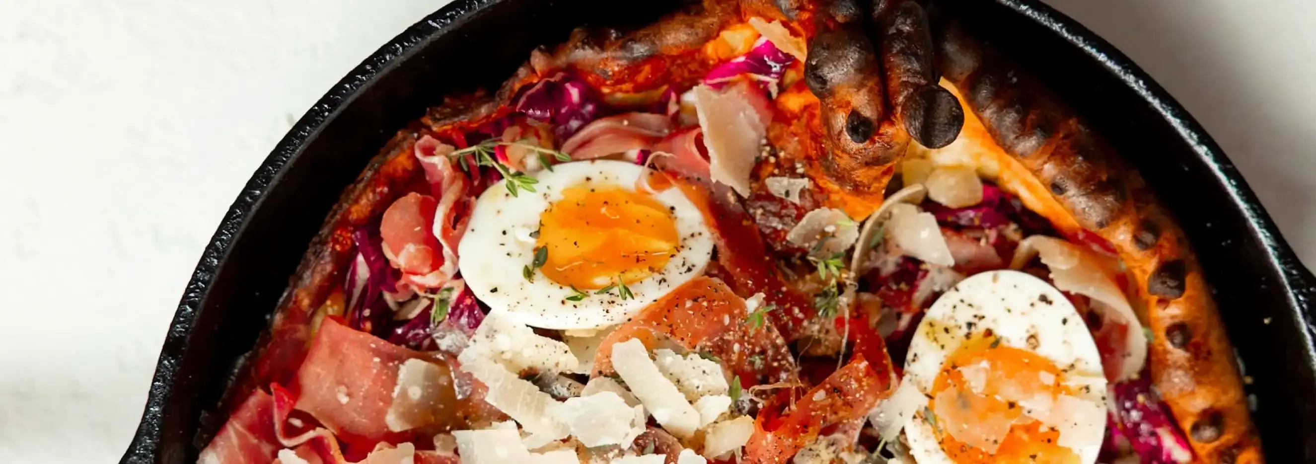 Delicious Savory Dutch Baby with eggs, ham, and herbs in a skillet