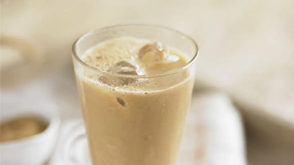 Refreshing almond mocha iced coffee served in a tall glass, garnished with whipped cream and a sprinkle of cocoa powder, ideal for a cool and energizing treat.