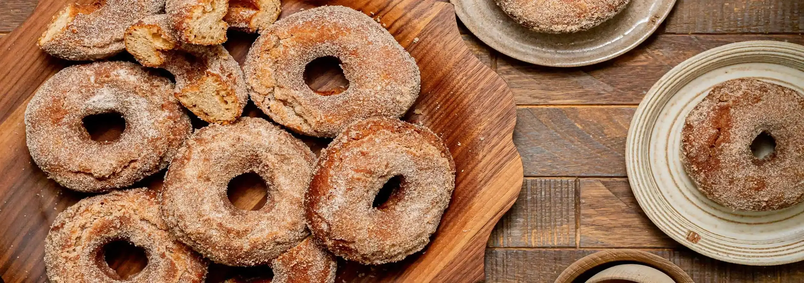Old Fashioned Apple Cider Donuts on a rustic wooden tray, dusted with cinnamon sugar for a delightful fall treat.