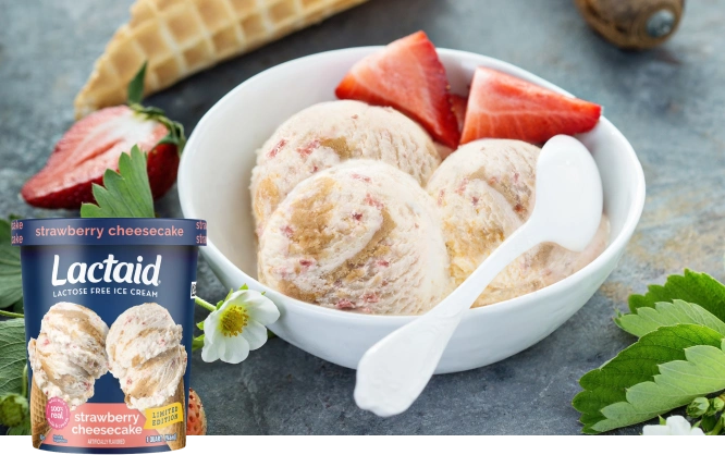 Un recipiente de helado LACTAID de pastel de queso con fresas